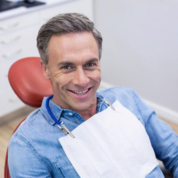 A man smiles while sitting in the dentist’s chair