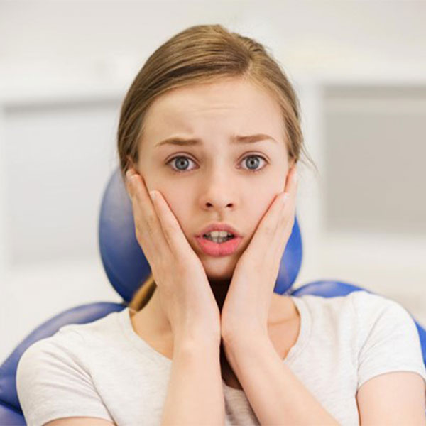 Girl clutches her face in fear, demonstrating the need for sedation dentistry in Fairfield, CT
